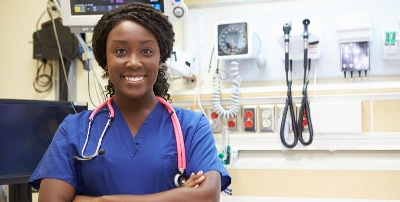 Smiling Nurse in Room with Monitors and Equipment