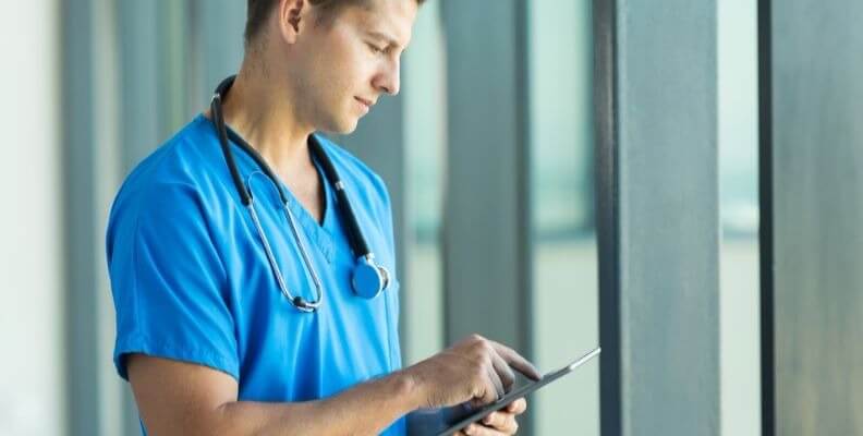 Male Nurse Using Tablet to Document