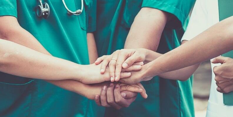 Nurses in Group with Hands Joined