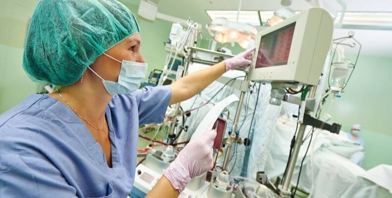 Operating Room Nurse Adjusting Monitors