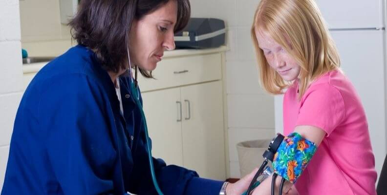 School Nurse with Child Taking Blood Pressure